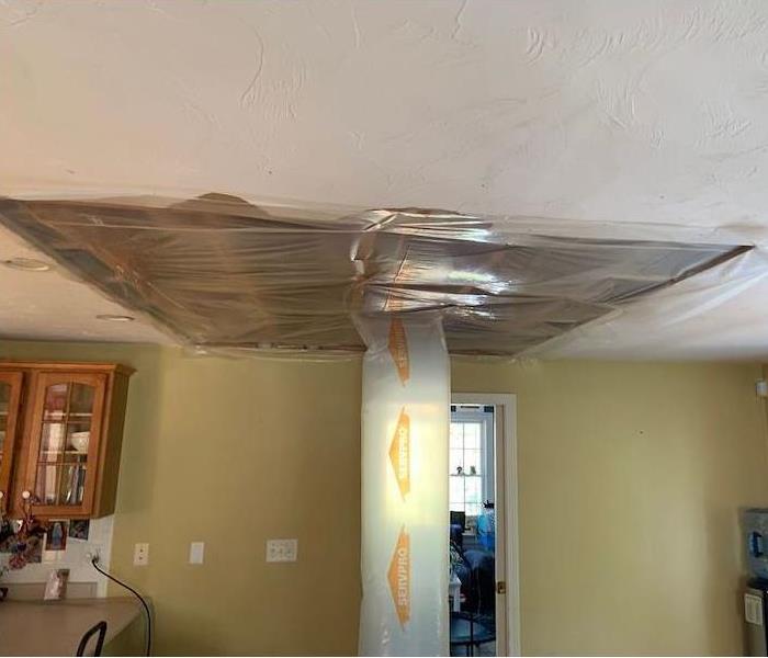 SERVPRO drying equipment connected to ceiling via plastic tube