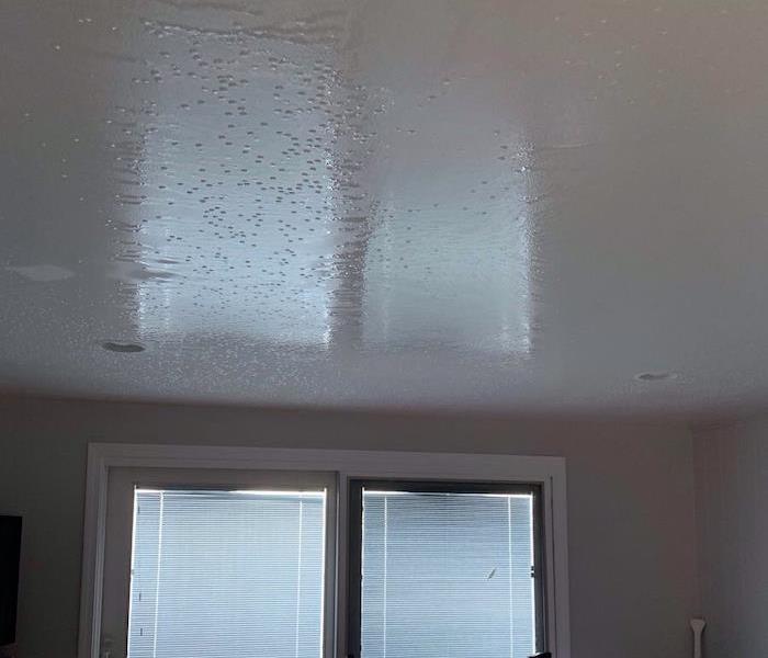 Ceiling with water damage showing in bedroom