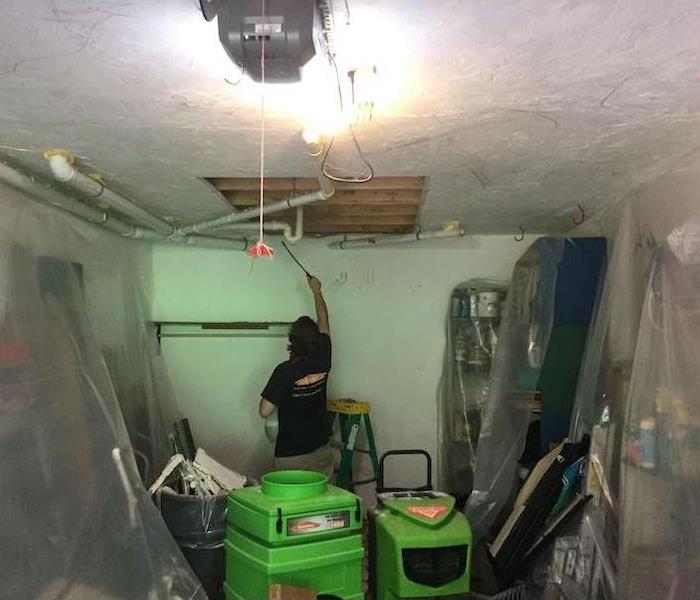SERVPRO tech in room with removed ceiling