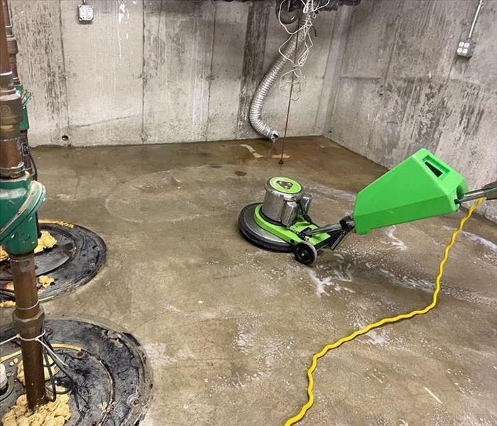 Rotary floor cleaner with cleaning solution on a concrete floor