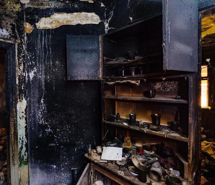 Burnt house interior. Burned furniture, kitchen cabinet, charred walls and ceiling in black soot